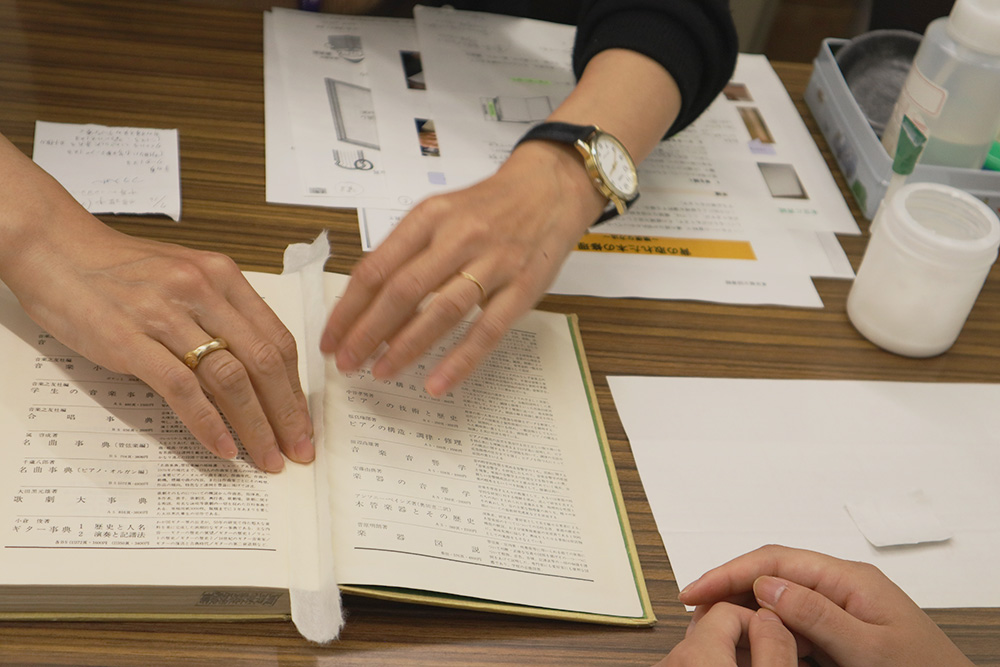 和紙や専用の糊をつかって、割れたページを修復する様子