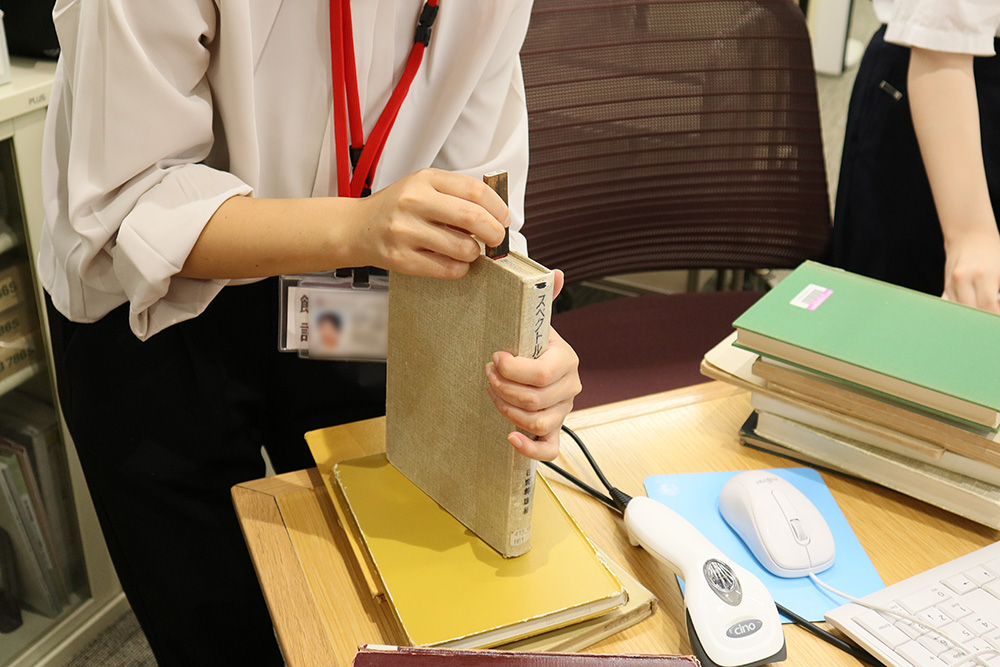 ピックアップした古い本に「書庫」の印を押す様子