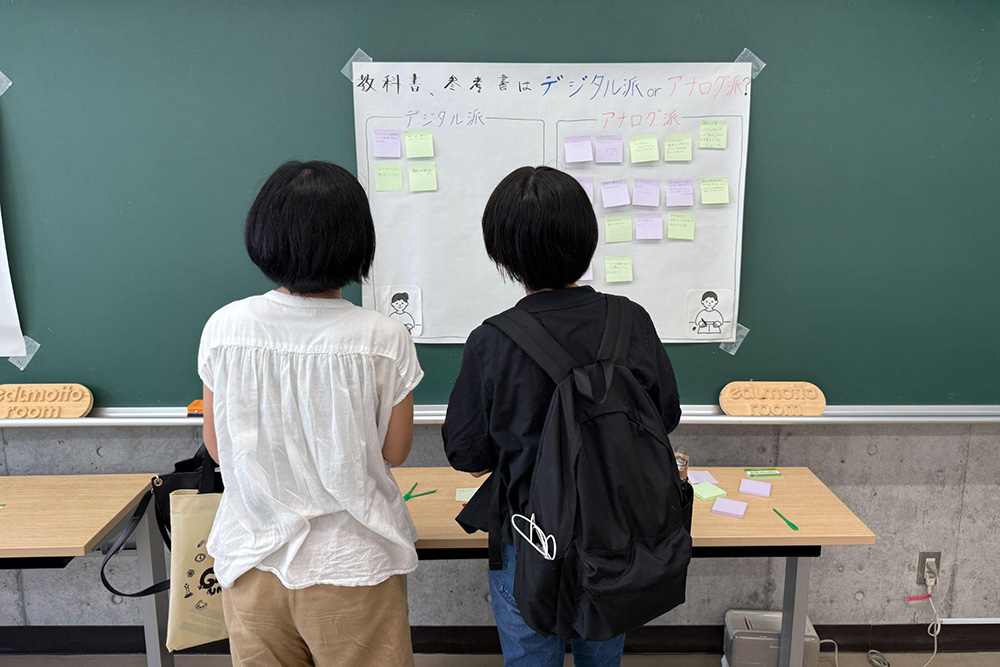 模造紙に貼られた付箋の回答をじっくり眺める来場者親子。回答はアナログ派が多数。