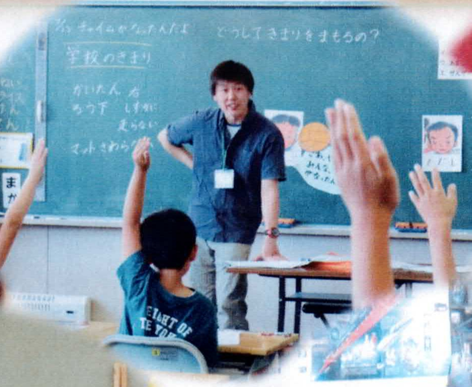 授業で教壇に立つ浅部先生と手を挙げる子どもたちの様子